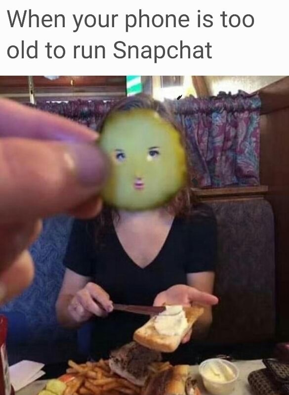 Man holding up pickle to woman's face as what we did before snapchat.