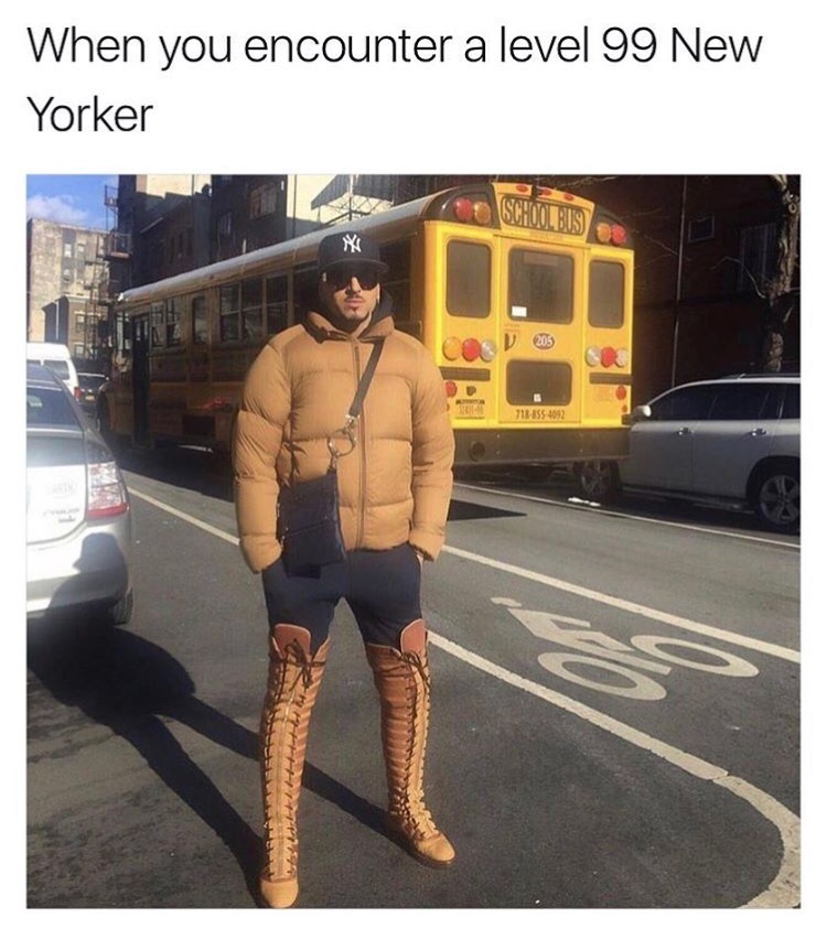 Level 99 New Yorker wearing boots and NY Yankees hat in front of a school bus.