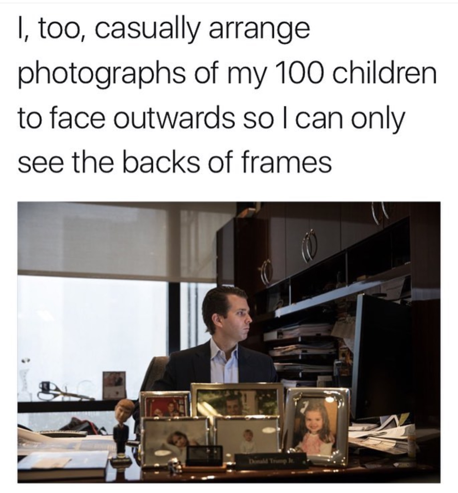 Dank meme of Eric Trump casually arranging his kids pictures outward on his desk.