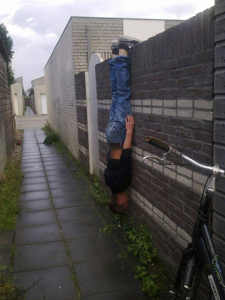 man hanging off a wall by his feet