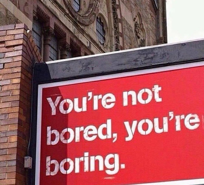 sign on a red brick building saying you're not bored, you're boring