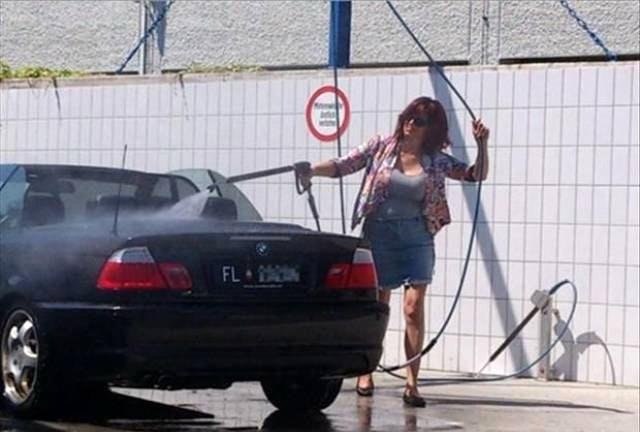 woman power washing her convertible with the top down