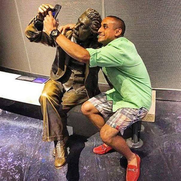 man posing for selfie with a statue in the perfect pose
