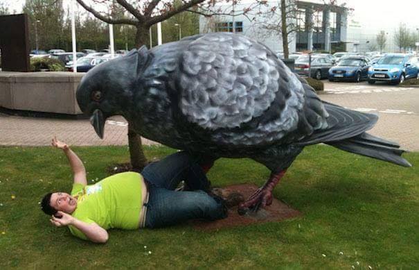 man being attacked by giant pigeon statue