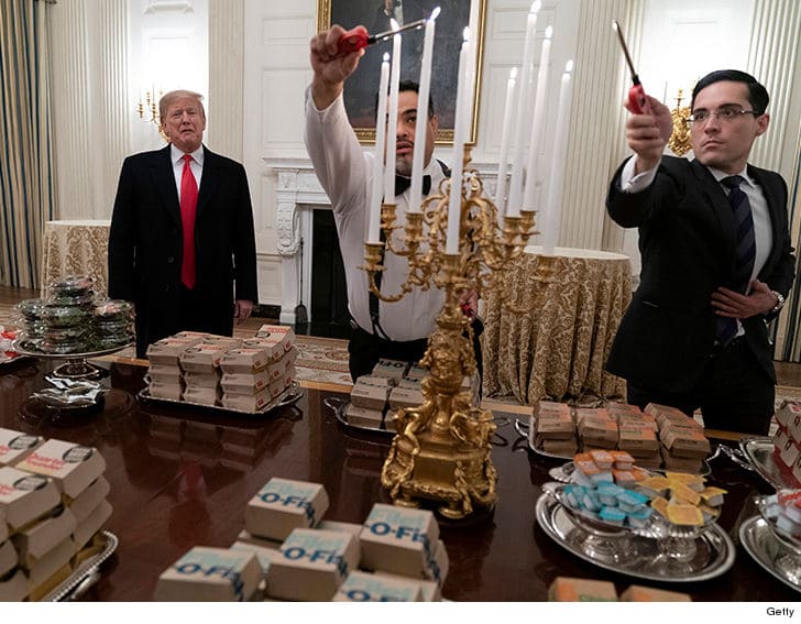 pic of White House employees lighting candles on a table full of takeout boxes with Trump watching from behind