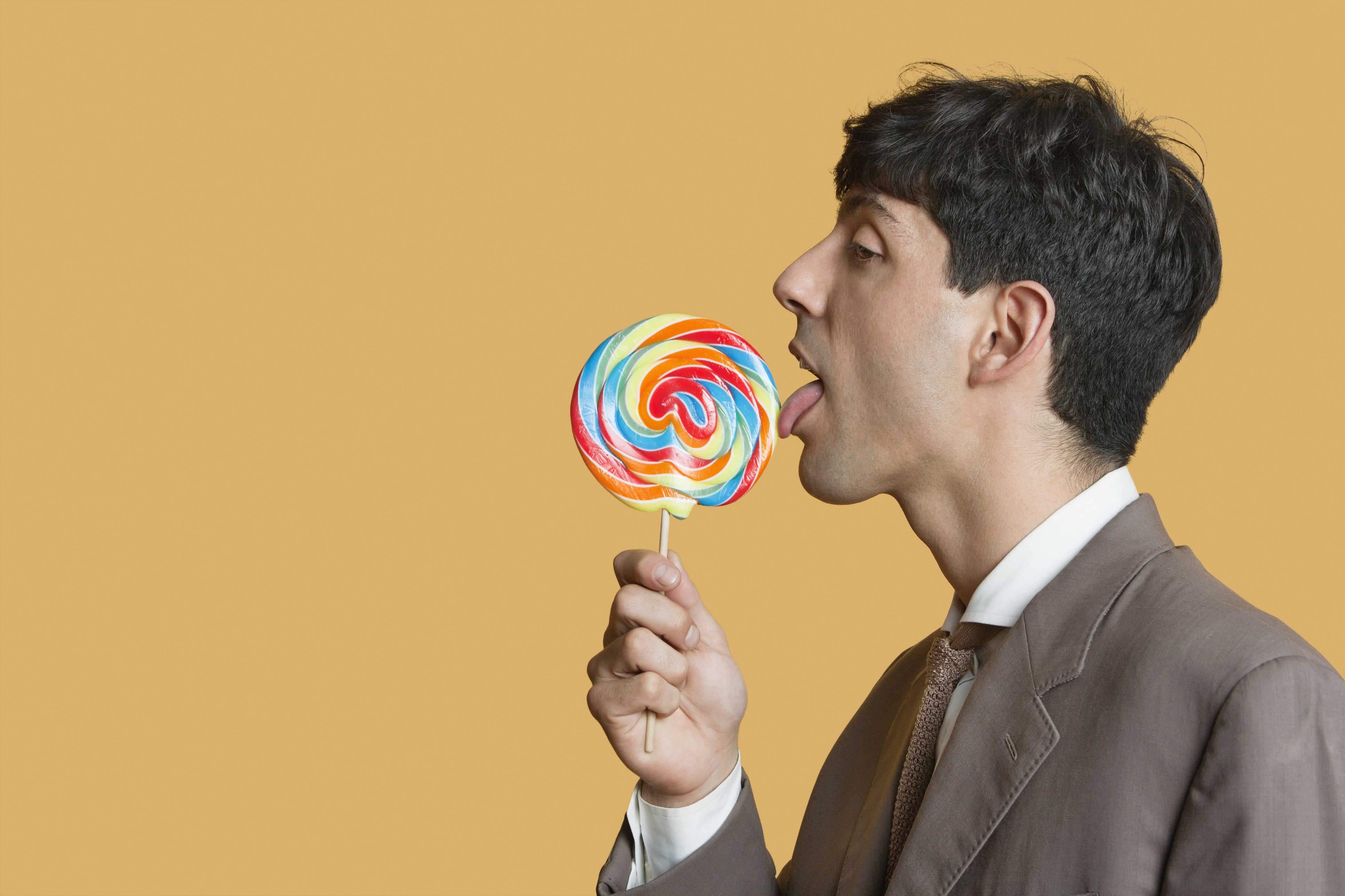 man licking lollipop