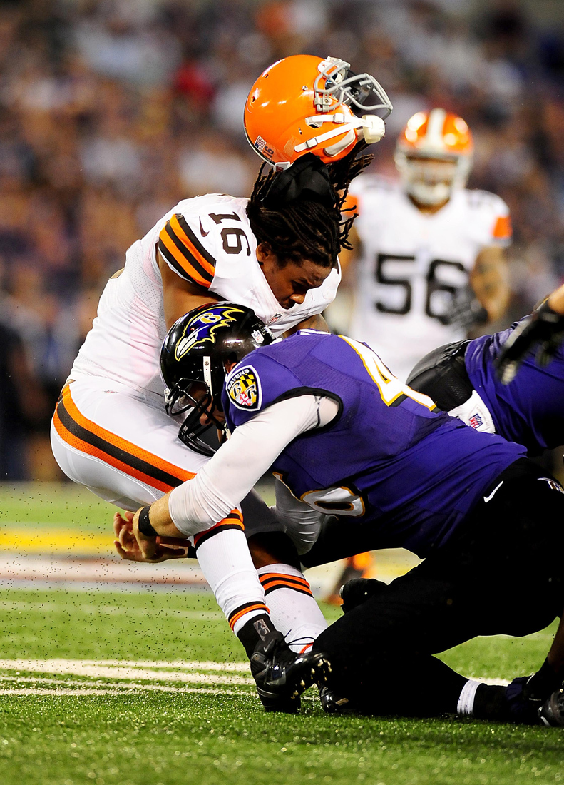 Cleveland Browns return man John Cribbs losing his helmet while getting hit hard by a Ravens football player. 