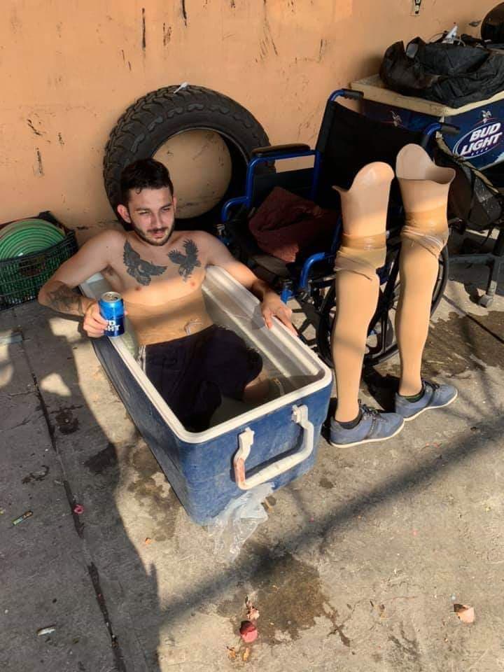 man with no legs cooling off in beer cooler filled with water