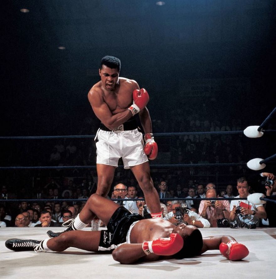 Muhammad Ali Vs. Sonny Liston, Neil Leifer, 1965

So much of great photography is being in the right spot at the right moment. That was what it was like for sports illustrated photographer Neil Leifer when he shot perhaps the greatest sports photo of the century. “I was obviously in the right seat, but what matters is I didn’t miss,” he later said. Leifer had taken that ringside spot in Lewiston, Maine, on May 25, 1965, as 23-year-old heavyweight boxing champion Muhammad Ali squared off against 34-year-old Sonny Liston, the man he’d snatched the title from the previous year. One minute and 44 seconds into the first round, Ali’s right fist connected with Liston’s chin and Liston went down. Leifer snapped the photo of the champ towering over his vanquished opponent and taunting him, “Get up and fight, sucker!” Power­ful overhead lights and thick clouds of cigar smoke had turned the ring into the perfect studio, and Leifer took full advantage. His perfectly composed image captures Ali radiating the strength and poetic brashness that made him the nation’s most beloved and reviled athlete, at a moment when sports, politics and popular culture were being squarely battered in the tumult of the ’60s.
