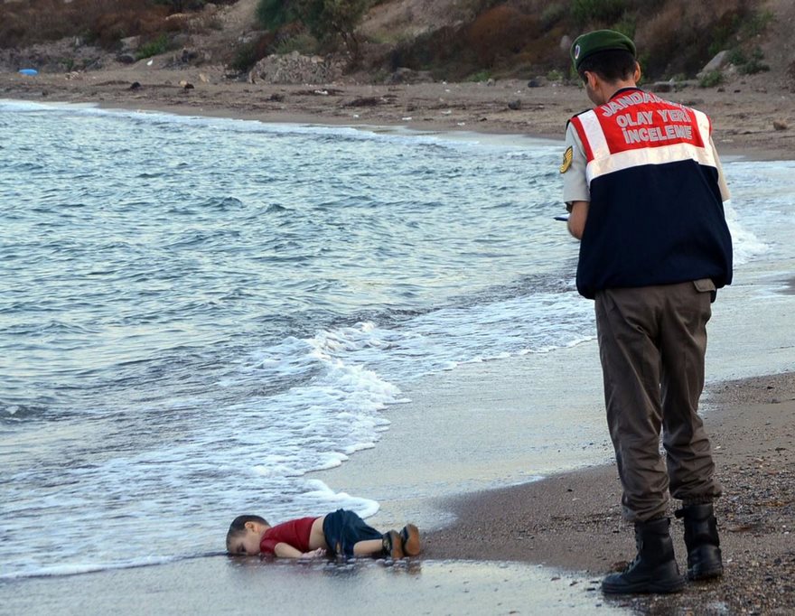 Alan Kurdi, Nilüfer Demir, 2015

The war in Syria had been going on for more than four years when Alan Kurdi’s parents lifted the 3-year-old boy and his 5-year-old brother into an inflatable boat and set off from the Turkish coast for the Greek island of Kos, just three miles away. Within minutes of pushing off, a wave capsized the vessel, and the mother and both sons drowned. On the shore near the coastal town of Bodrum a few hours later, Nilufer Demir of the Dogan News Agency, came upon Alan, his face turned to one side and bottom elevated as if he were just asleep. “There was nothing left to do for him. There was nothing left to bring him back to life,” she said. So Demir raised her camera. "I thought, This is the only way I can express the scream of his silent body." The resulting image became the defining photograph of an ongoing war that, by the time Demir pressed her shutter, had killed some 220,000 people. It was taken not in Syria, a country the world preferred to ignore, but on the doorstep of Europe, where its refugees were heading. Dressed for travel, the child lay between one world and another: waves had washed away any chalky brown dust that might locate him in a place foreign to Westerners’ experience. It was an experience the Kurdis sought for themselves, joining a migration fueled as much by aspiration as desperation. The family had already escaped bloodshed by making it across the land border to Turkey; the sea journey was in search of a better life, one that would now become — at least for a few months — far more accessible for the hundreds of thousands traveling behind them. Demir’s image whipped around social media within hours, accumulating potency with every share. News organizations were compelled to publish it—or publicly defend their decision not to. And European governments were suddenly compelled to open closed frontiers. Within a week, trainloads of Syrians were arriving in Germany to cheers, as a war lamented but not felt suddenly brimmed with emotions unlocked by a picture of one small, still form.