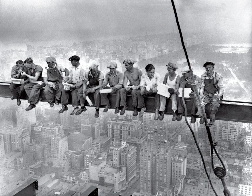 Lunch Atop A Skyscraper, 1932

It’s the most perilous yet playful lunch break ever captured: 11 men casually eating, chatting and sneaking a smoke as if they weren’t 840 feet above Manhattan with nothing but a thin beam keeping them aloft. That comfort is real; the men are among the construction workers who helped build Rockefeller Center. But the picture, taken on the 69th floor of the flagship RCA Building (now the GE Building), was staged as part of a promotional campaign for the massive skyscraper complex. While the photographer and the identities of most of the subjects remain a mystery—the photographers Charles C. Ebbets, Thomas Kelley and William Leftwich were all present that day, and it’s not known which one took it—there isn’t an ironworker in New York City who doesn’t see the picture as a badge of their bold tribe. In that way they are not alone. By thumbing its nose at both danger and the Depression, Lunch Atop a Skyscraper came to symbolize American resilience and ambition at a time when both were desperately needed. It has since become an iconic emblem of the city in which it was taken, affirming the romantic belief that New York is a place unafraid to tackle projects that would cow less brazen cities. And like all symbols in a city built on hustle, Lunch Atop a Skyscraper has spawned its own economy. It is the Corbis photo agency’s most reproduced image. And good luck walking through Times Square without someone hawking it on a mug, magnet or T-shirt.