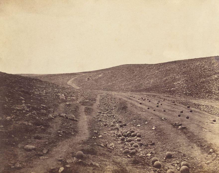 The Valley Of The Shadow Of Death, Roger Fenton, 1855. While little is remembered of the Crimean War—that nearly three-year conflict that pitted England, France, Turkey and Sardinia-Piedmont against Russia—coverage of it radically changed the way we view war. Until then, the general public learned of battles through heroic paintings and illustrations. But after the British photographer Roger Fenton landed in 1855 on that far-off peninsula on the Black Sea, he sent back revelatory views of the conflict that firmly established the tradition of war photography. Those 360 photos of camp life and men manning mortar batteries may lack the visceral brutality we have since become accustomed to, yet Fenton’s work showed that this new artistic medium could rival the fine arts. This is especially clear in The Valley of the Shadow of Death, which shows a cannonball-strewn gully not far from the spot immortalized in Alfred, Lord Tennyson’s “The Charge of the Light Brigade.” That haunting image, which for many evokes the poem’s “Cannon to right of them,/ Cannon to left of them,/ Cannon in front of them” as the troops race “into the valley of Death,” also revealed to the general public the reality of the lifeless desolation left in the wake of senseless slaughter. Scholars long believed that this was Fenton’s only image of the valley. But a second version with fewer of the scattered projectiles turned up in 1981, fueling a fierce debate over which came first. That the more recently discovered picture is thought to be the first indicates that Fenton may have been one of the earliest to stage a news photograph.