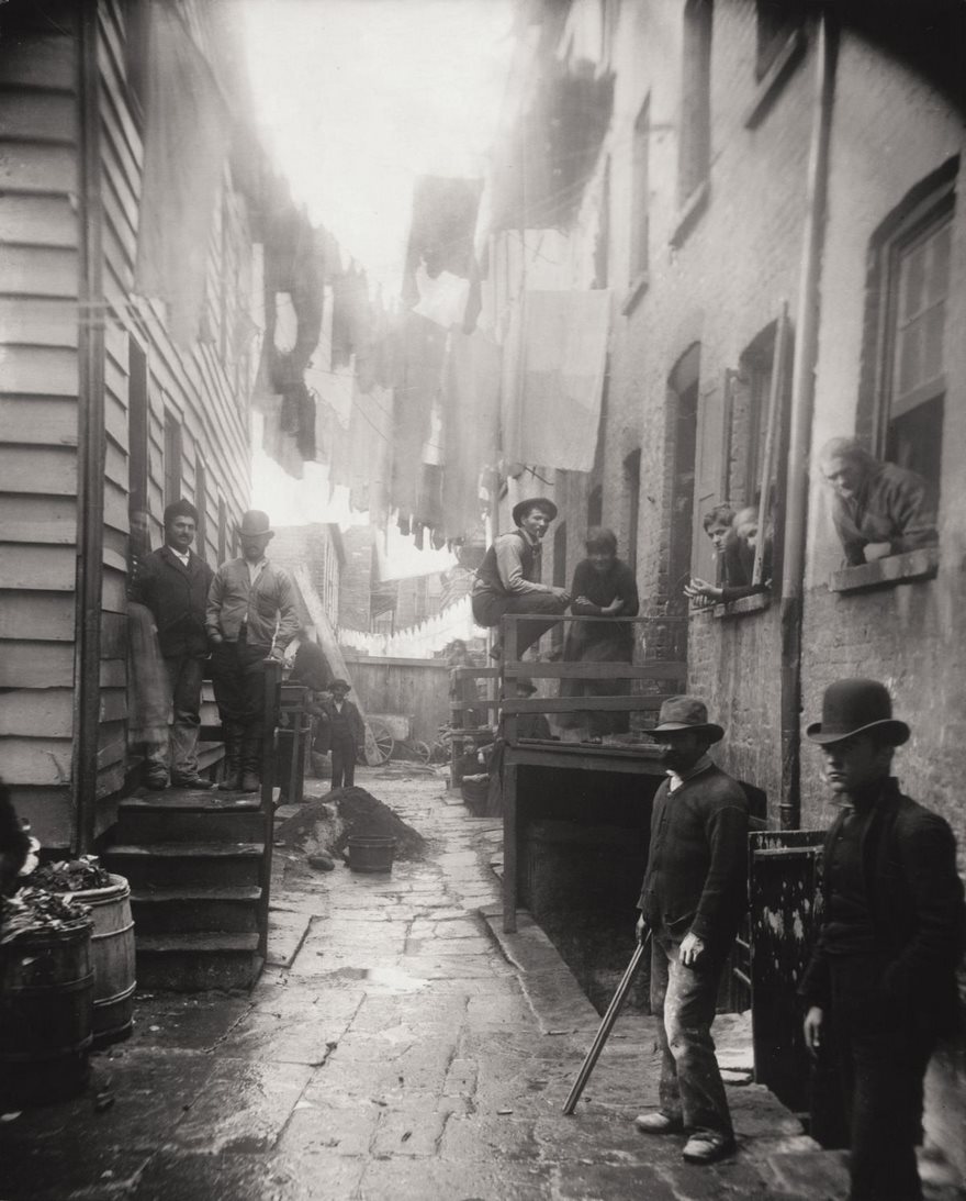 Bandit's Roost, Mulberry Street, Jacob Riis, Circa 1888. Late 19th-century New York City was a magnet for the world’s immigrants, and the vast majority of them found not streets paved with gold but nearly subhuman squalor. While polite society turned a blind eye, brave reporters like the Danish-born Jacob Riis documented this shame of the Gilded Age. Riis did this by venturing into the city’s most ominous neighborhoods with his blinding magnesium flash powder lights, capturing the casual crime, grinding poverty and frightful overcrowding. Most famous of these was Riis’ image of a Lower East Side street gang, which conveys the danger that lurked around every bend. Such work became the basis of his revelatory book How the Other Half Lives, which forced Americans to confront what they had long ignored and galvanized reformers like the young New York politician Theodore Roosevelt, who wrote to the photographer, “I have read your book, and I have come to help.” Riis’ work was instrumental in bringing about New York State’s landmark Tenement House Act of 1901, which improved conditions for the poor. And his crusading approach and direct, confrontational style ushered in the age of documentary and muckraking photojournalism.