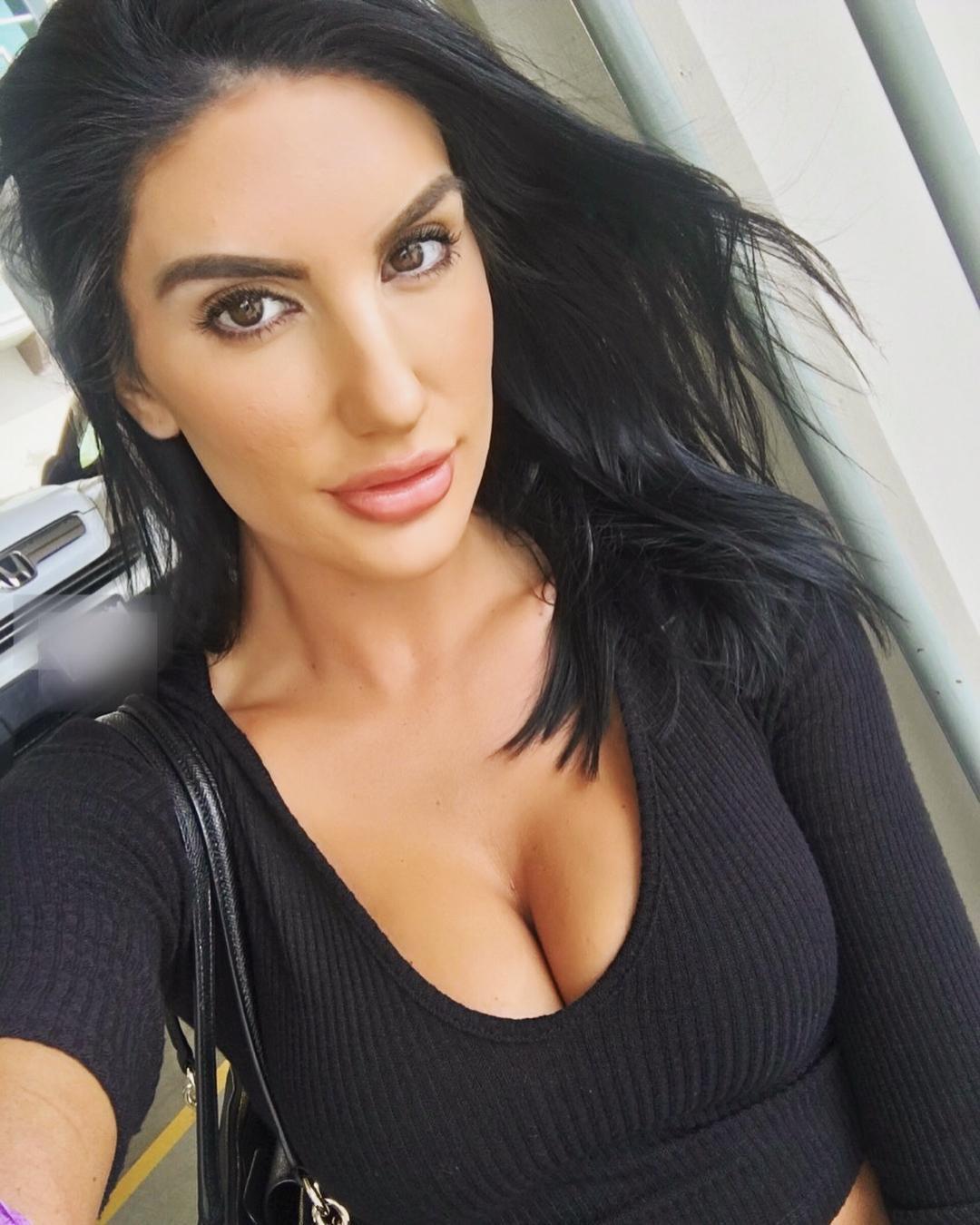 Extremely cute pornstar August Ames in a low cut black shirt