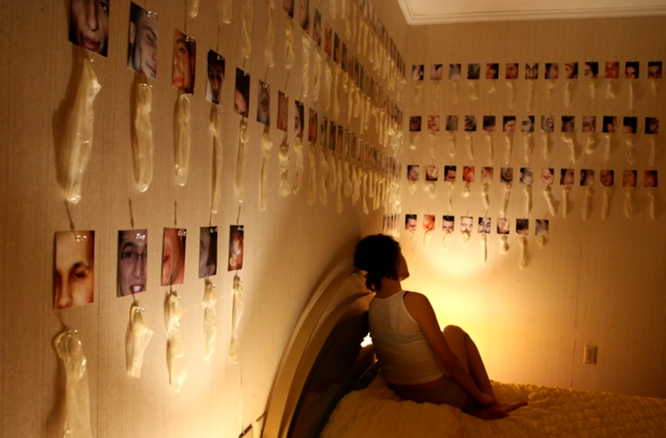 A strange and weird image of a girl in a room full of pictures and condoms.