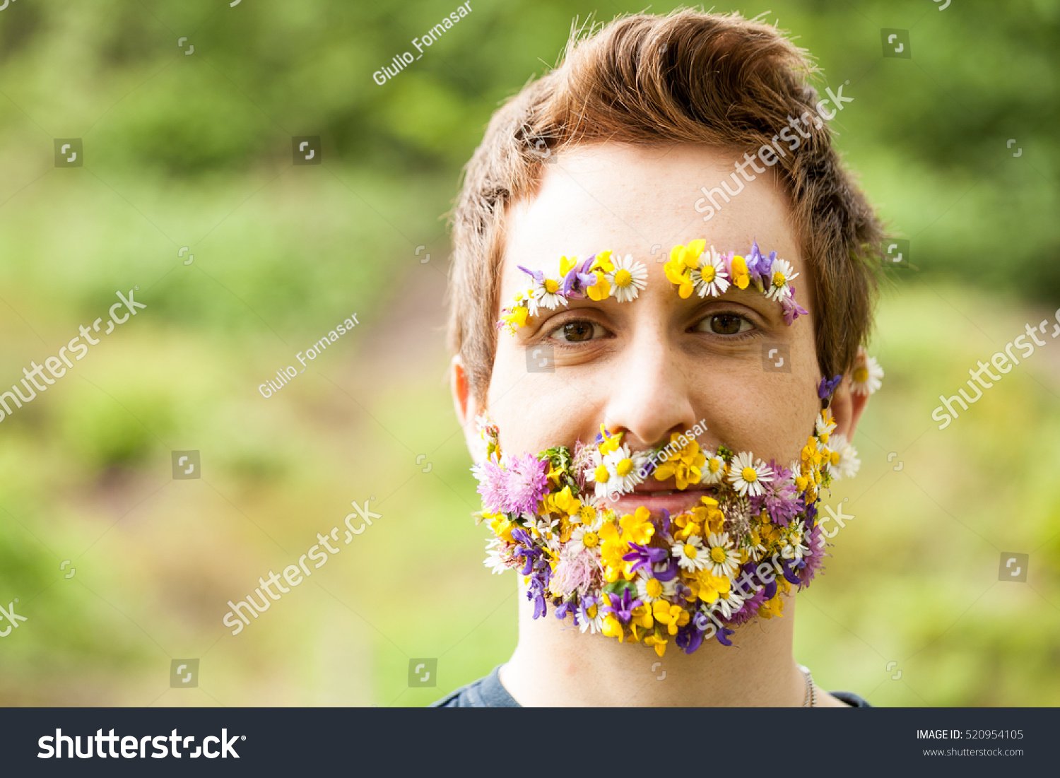 A crazy and weird stock photo of a man with flowers for a beard and eyebrows. 