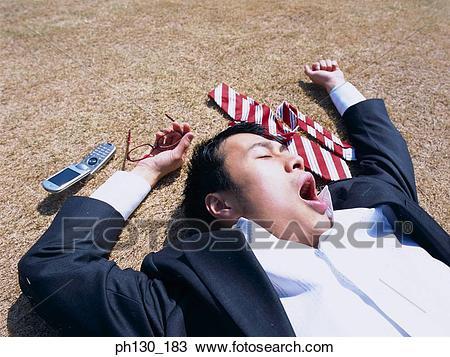 An odd stock photo of a business man on the ground with his arms stretched out.