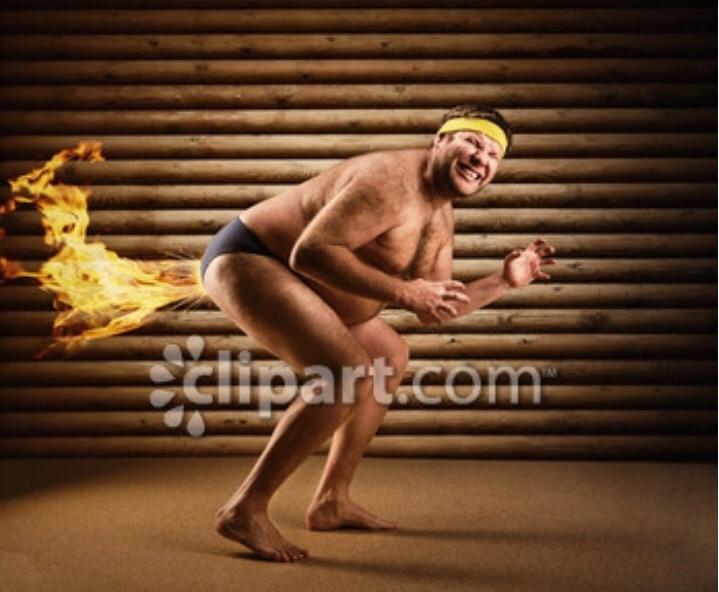 A hilarious and weird stock photo of a man wearing a speedo and headband farting out fire. 