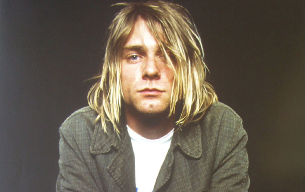 A photo of Kurt Cobain looking sad with his hair in his face.