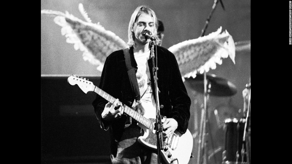 A photo of Kurt Cobain playing guitar with what looks like angel wings behind him.
