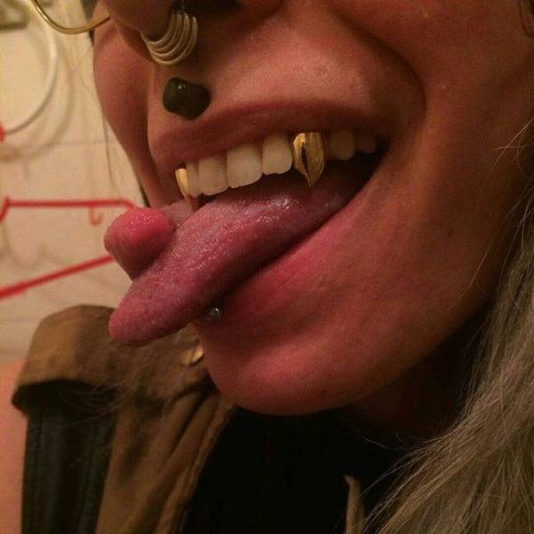 Crazy picture of woman with gold canines and a split tongue