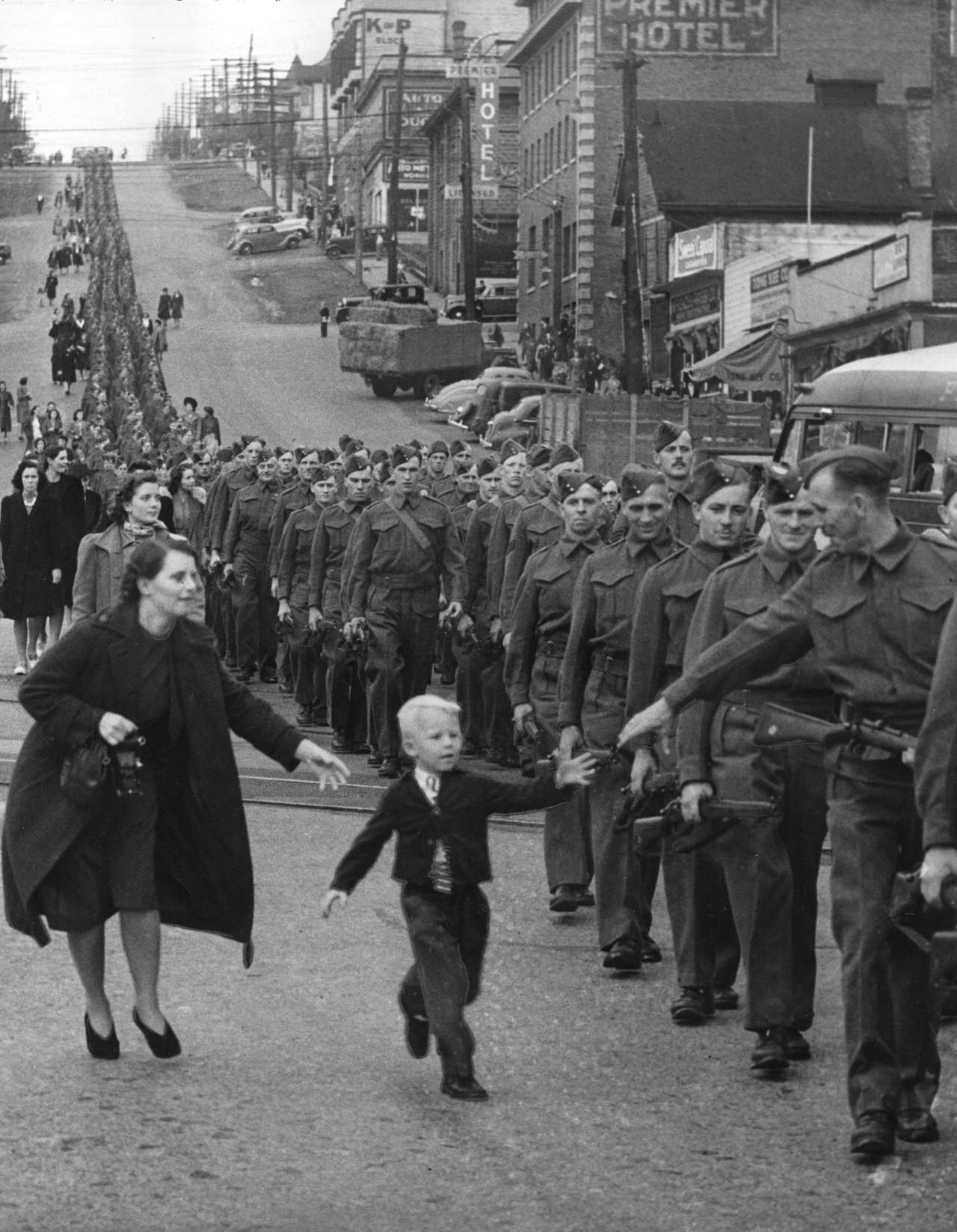 .Wait for Me, Daddy is a photo taken by Claude P. Dettloff on October 1, 1940. The British Columbia Regiment was marching down Eighth Street in British Columbia after Hitler threatened Poland and demanded the town of Danzig. While Dettloff was taking the photo, Warren "Whitey" Bernard ran away from his mother to his father, Private Jack Bernard. The picture received extensive exposure and was used in war-bond drives.
