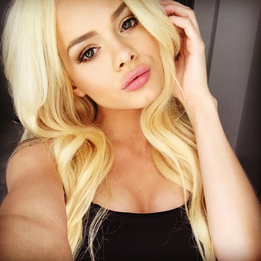 Elsa Jean with pink lipstick on and a black tank top on.