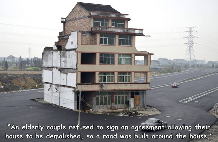 house in the middle of the street - "An elderly couple refused to sign an agreement allowing their house to be demolished, so a road was built around the house."