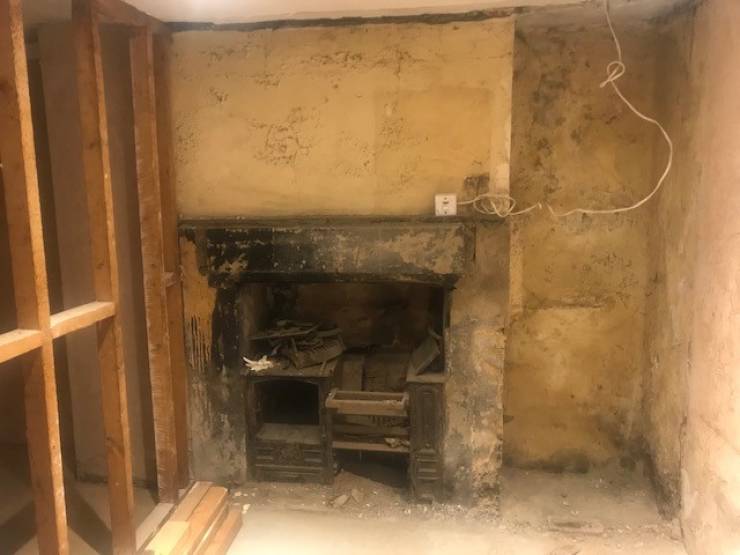 “A wall was removed in a Victorian house we are working at which revealed an old cast iron fireplace”