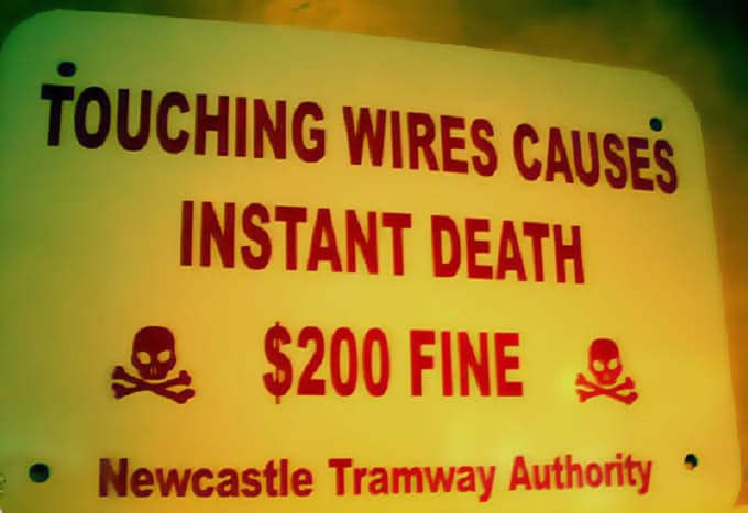 stupid road signs - Touching Wires Causes Instant Death $200 Fine Newcastle Tramway Authority