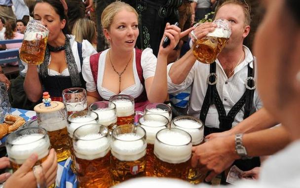 Hot girl at oktoberfest in front of a table full of beers