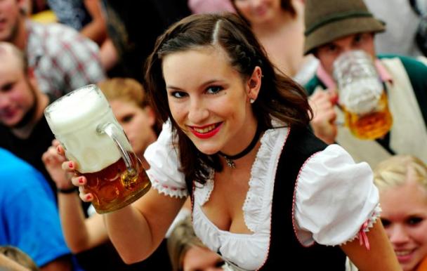 Hot girl at Oktoberfest smiling and holding a beer