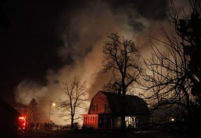 Smoke rises from a burning plane after it crashed into a house in Clarence Center, N.Y., Thursday Feb. 12, 2009. New York state police say a Continental Flight 3407 from Newark, N.J., a 50-passenger commuter plane, has crashed into a home in suburban Buffalo.