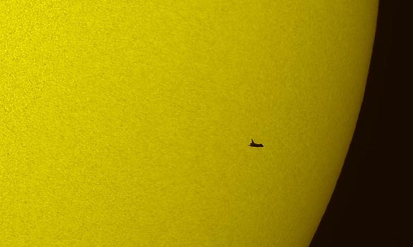 Shuttle in front of the sun