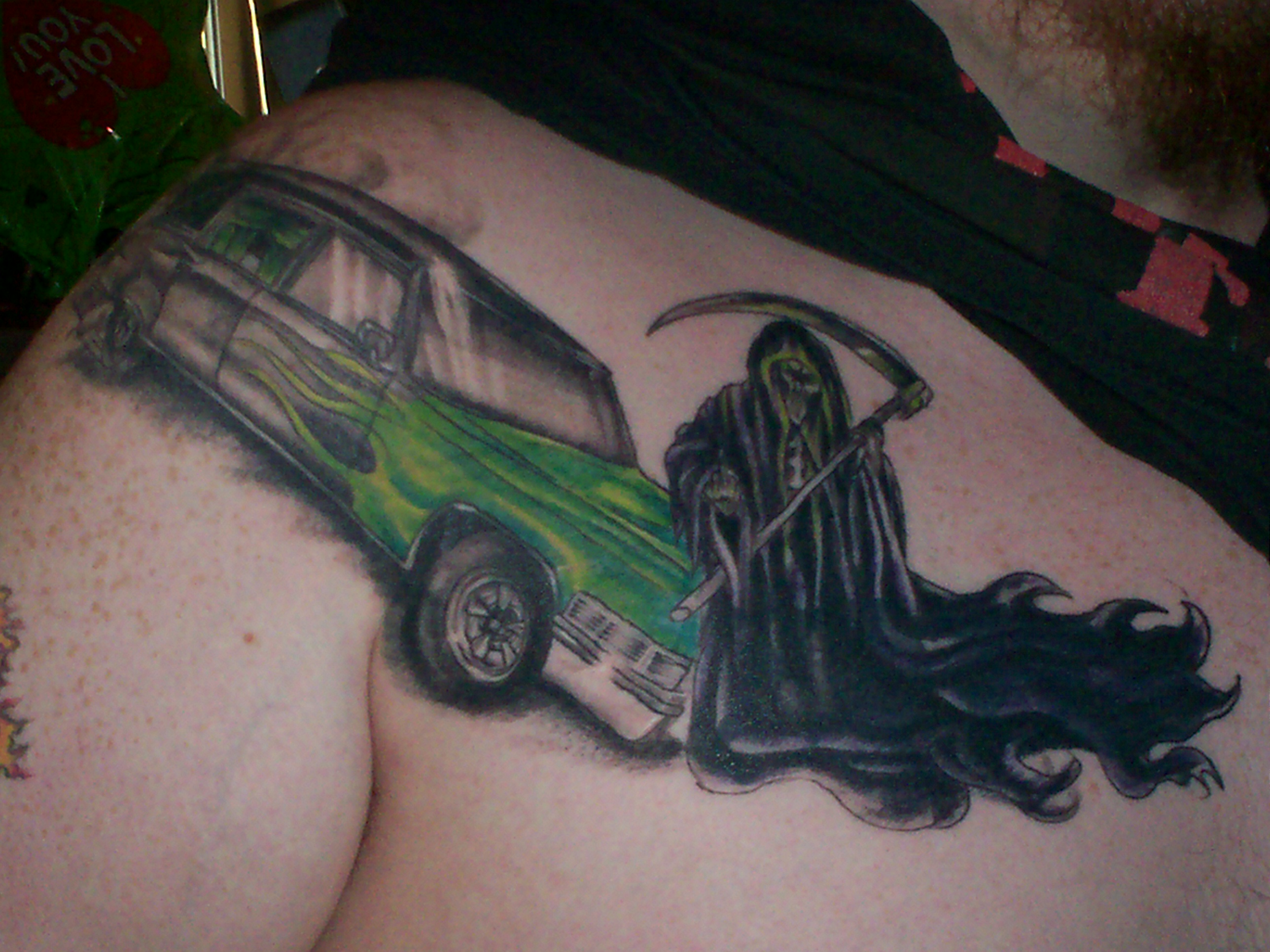 my favorite tattoo black hearse with green flames with the grim reaper flipping you off 