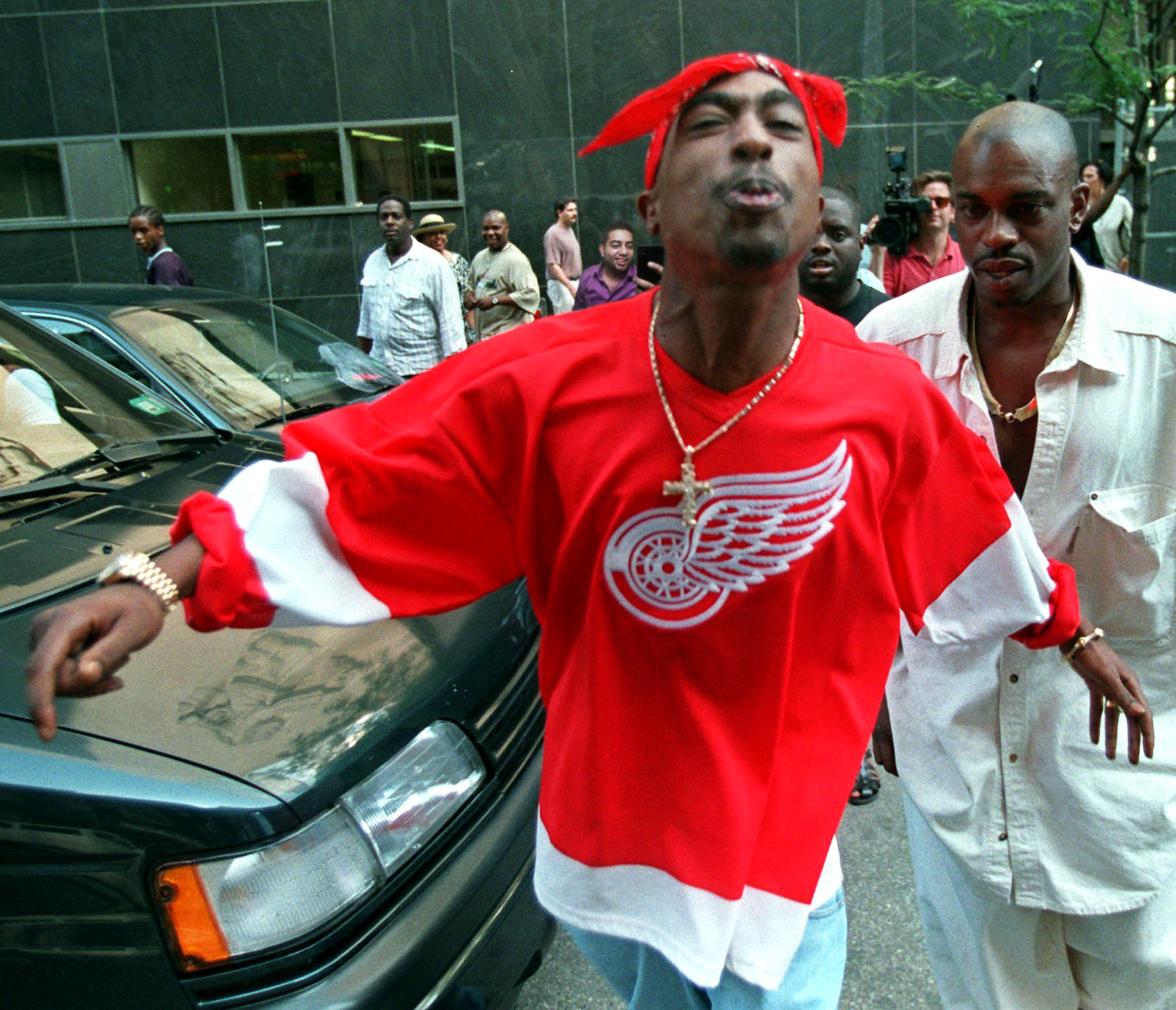 2Pac wearing an NHL Detroit Red Wings jersey spitting