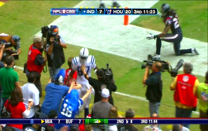 Reggie Wayne getting stiff armed by camera guy on the sidelines at Reliant Stadium in Houston, Texas.