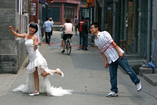 Bride and groom pose in hutong in Beijing