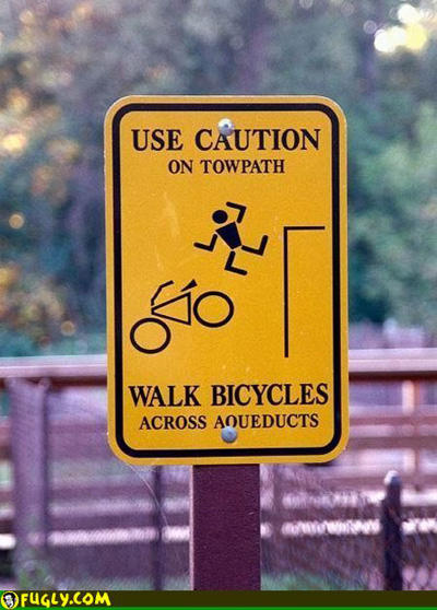 bizarre sign - Use Caution On Towpath Walk Bicycles Across Aqueducts Fugly.Com