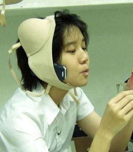 This Asian girl uses her bra to make a hands free phone. I guess she could not afford a blue tooth headset.
