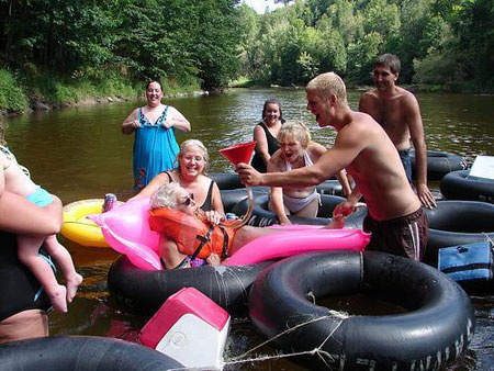 Grandma funnels a beer while floating the river