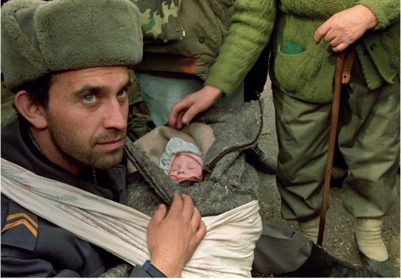 A Bosnian soldier cares for a baby he saved during the evacuation of Gorade. 1995
