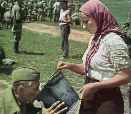 A soviet soldier is given water by a Ukrainian woman after being captured. 1941
