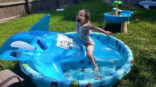 young girl playing in kiddie pool