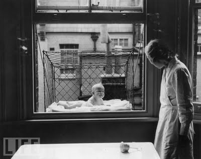 6 Baby Cage, 1937 A nanny supervising a baby suspended in a wire cage attached to the outside of a high tenement block window. The cages were distributed to members of the Chelsea Baby Club in London who have no gardens, or qualms about putting a child in a box dangling over a busy street.