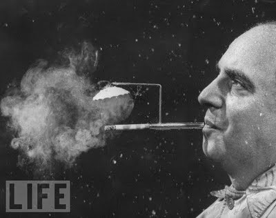 9 Rainy Day Cigarette Holder, 1954 President of Zeus Corp., Robert L. Stern, smoking a cigarette from his self-designed rainy day cigarette holder.