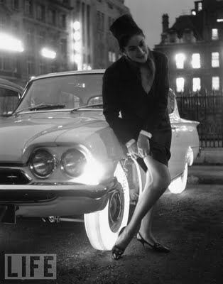 12 Illuminated Tires, 1961 A woman adjusts her stocking by the light of the Goodyear's illuminated tires. The tire is made from a single piece of synthetic rubber and is brightly lit by bulbs mounted inside the wheel rim.