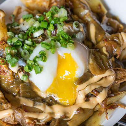 Kimchi 'n' Curry Poutine.  Braised pork and potatoes smothered with curry gravy and cheddar cheese, then topped with kimchi and a poached egg