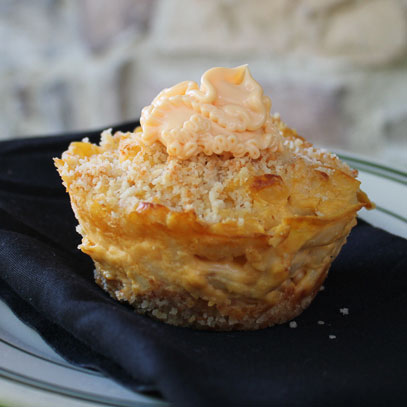 Mac & Cheese Cupcake.  Mac & cheese nestled in a breadcrumb crust, then sprinkled with breadcrumbs and frosted with a dollop of Cheez Whiz