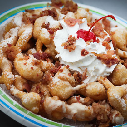 Maple Bacon Funnel Cake.  A funnel cake infused with bacon pieces, then topped with sweet maple glaze and sprinkled with more bacon